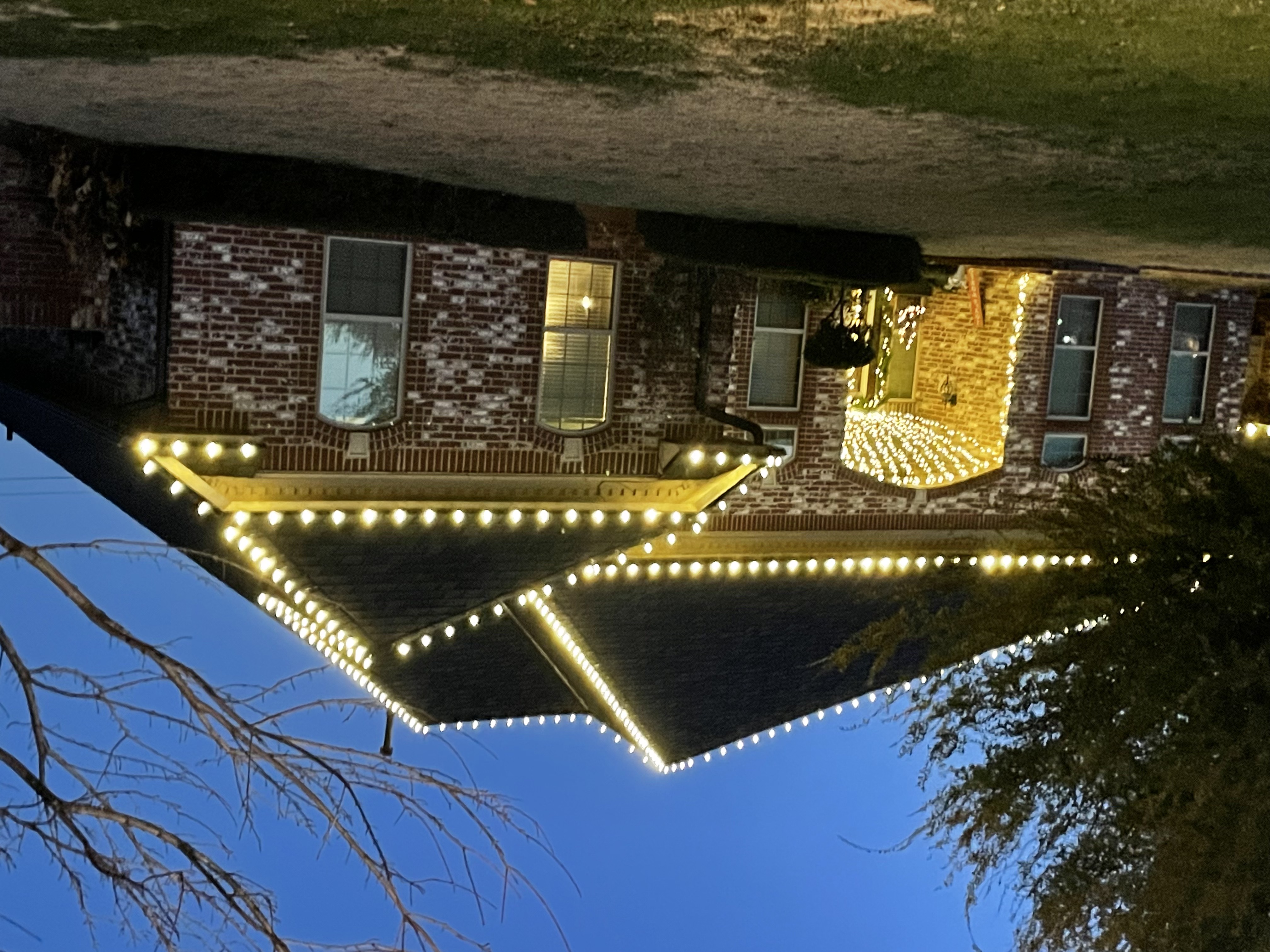 Classic Christmas lights installation on roofline and porch area of Village home